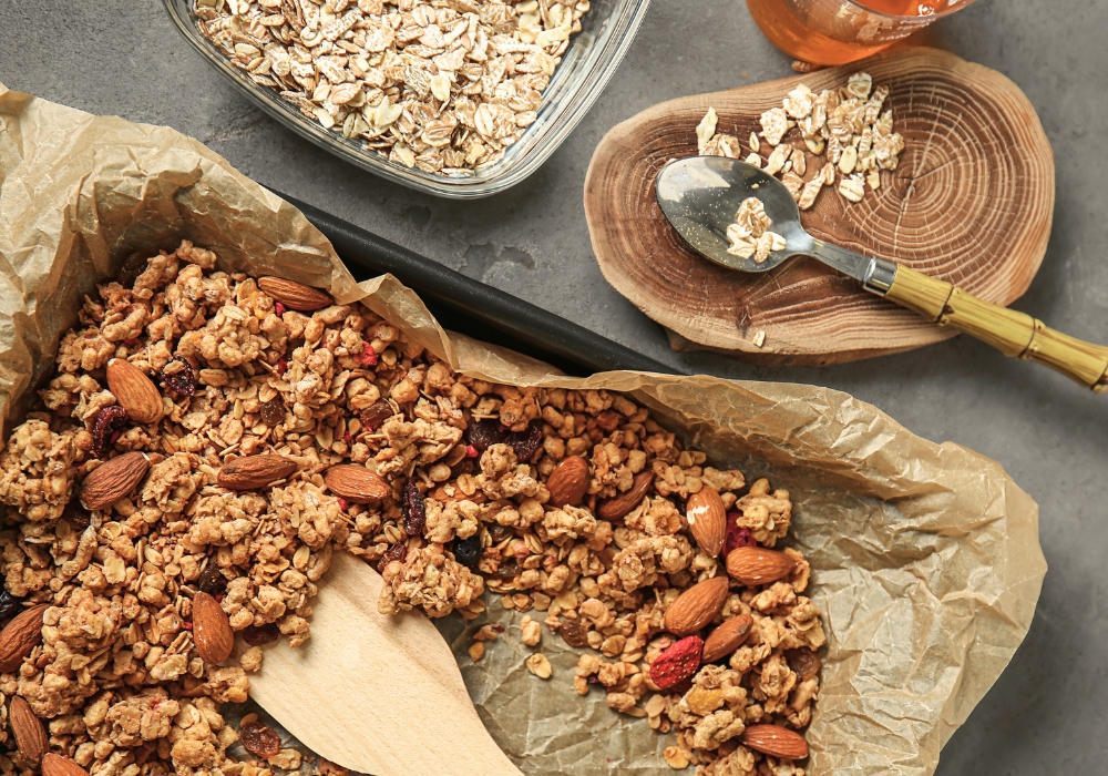 Kleine Kinderhände halten Schüsseln mit selbstgemachtem Granola und Früchten