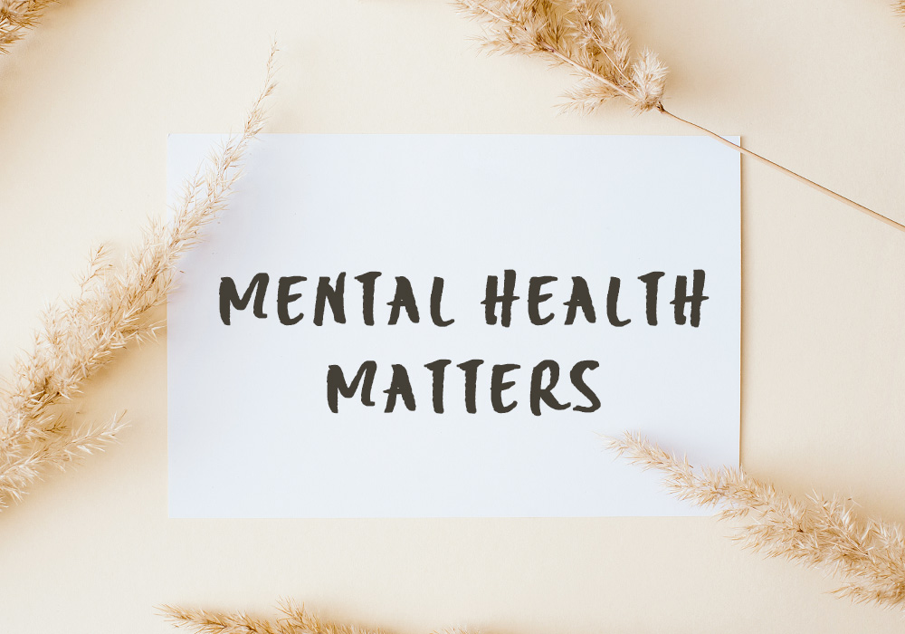 Die Worte "Mental Health Matters" stehen auf einem weißen Papier, welches auf beigem Untergrund liegt
