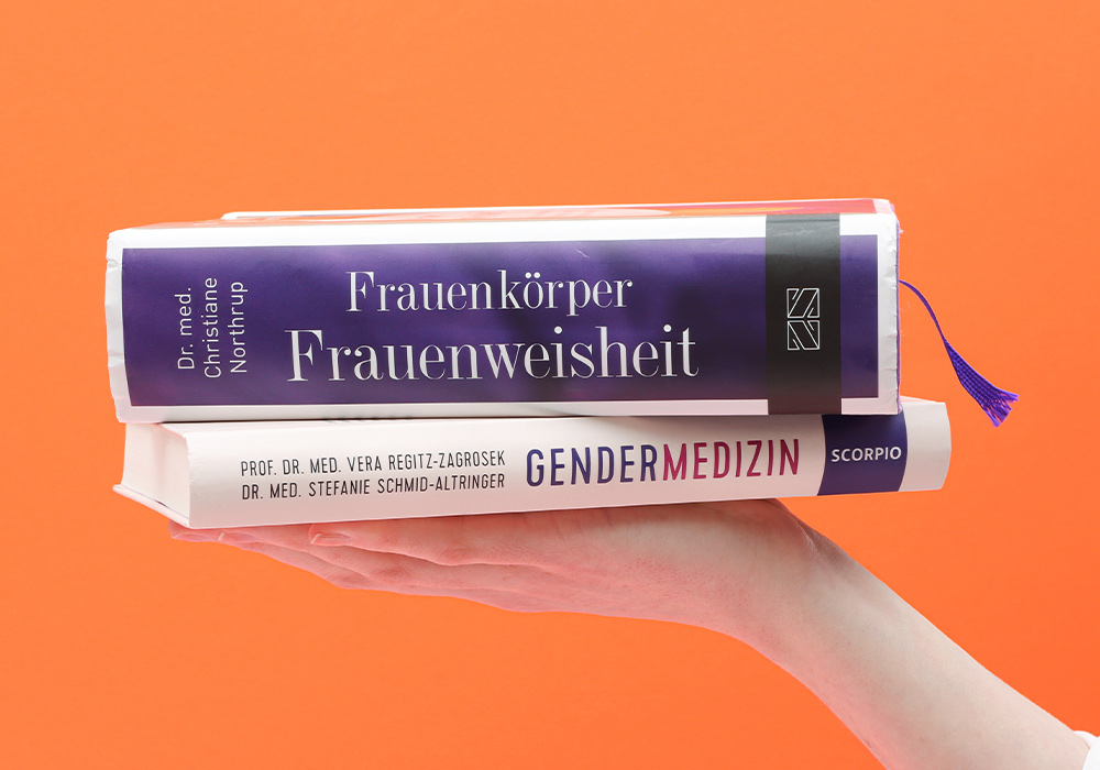 2 Bücher zum Thema Gendermedizin und Frauenweisheit auf einer Hand