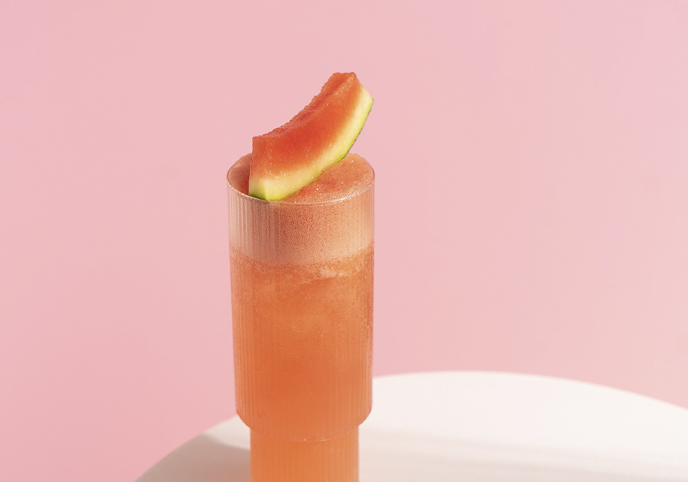 Glas mit Melonensaft und Melonendekoration.