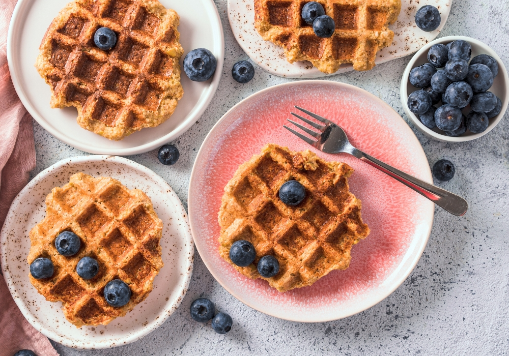 Süßkartoffelwaffel mit Blaubeeren auf weiß-pinken Keramiktellern