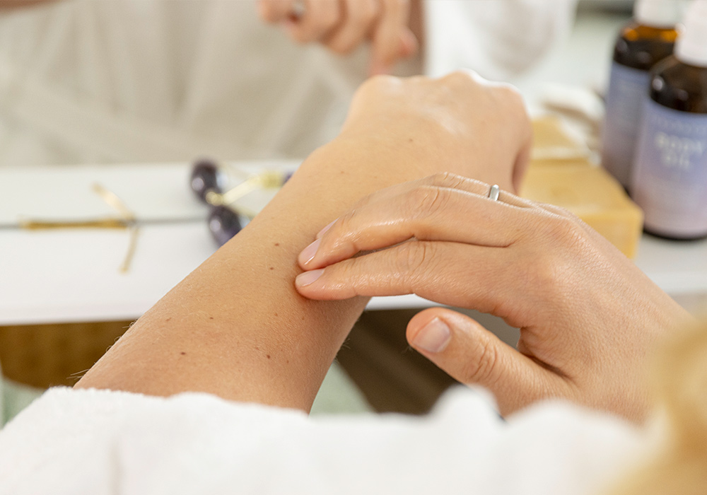 Frau wendet das InnoNature Stretch Mark Oil auf dem Oberarm an