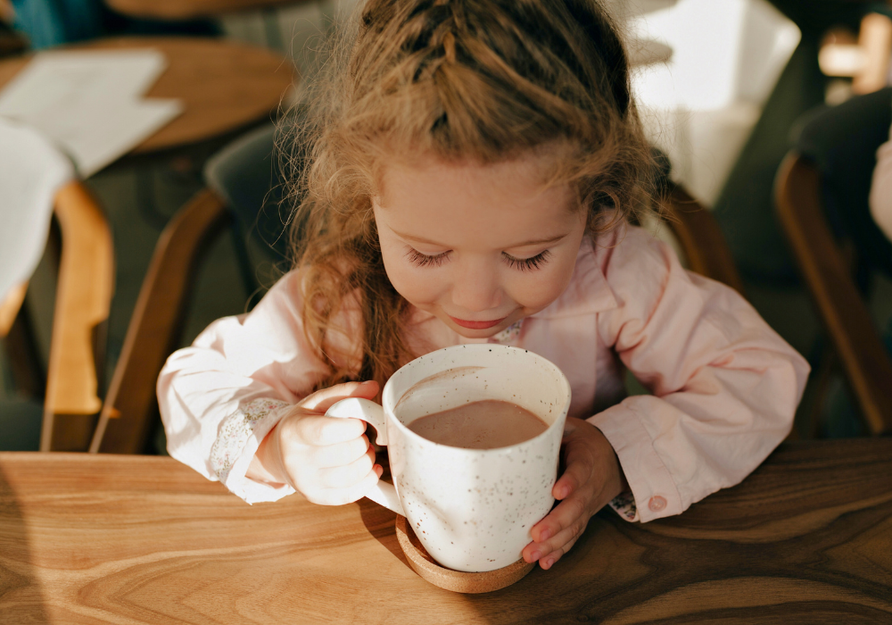 Kind trinkt Heißgetränk mit Karob aus Tasse