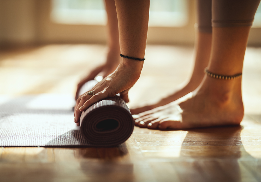 Person rollt ihre Sportmatte aus