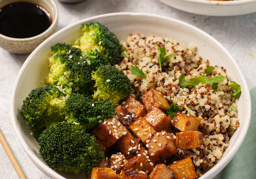 Teller mit Brokkoli, Tofu, Quinoa und grünem Blattgemüse