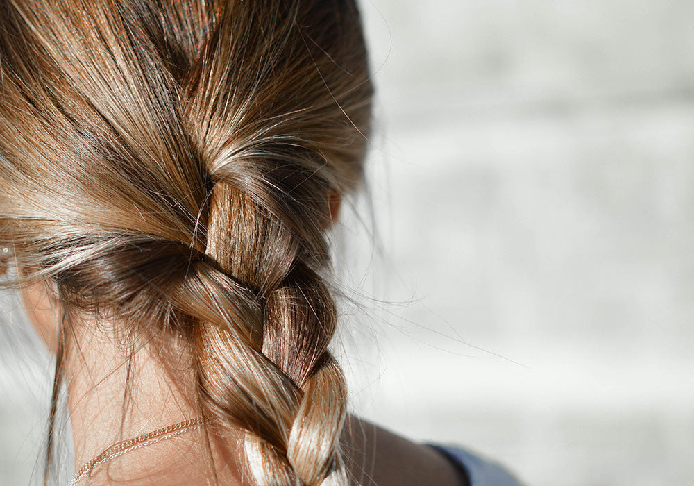 gesunde blonde Haare zu einem Zopf gebunden