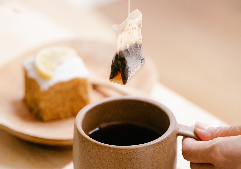 Teebeutel, der benutzt aus der Tasse gezogen wird. 