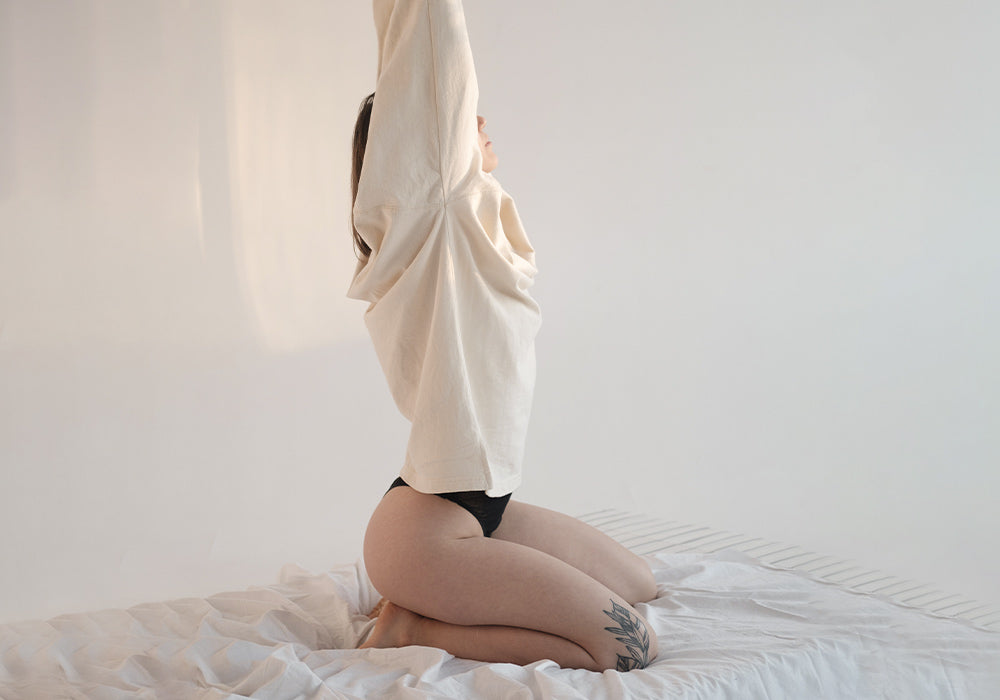 Frau streckt sich auf dem Bett