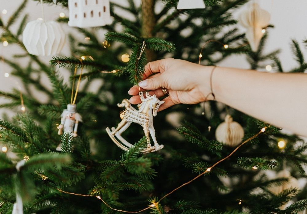 Jemand schmückt einen Tannenbaum