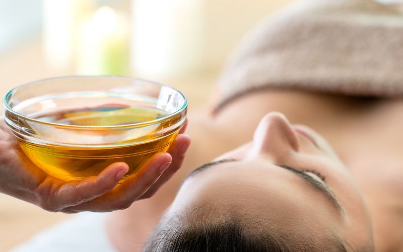 Frau wird mit Olivenöl ayurvedisch massiert
