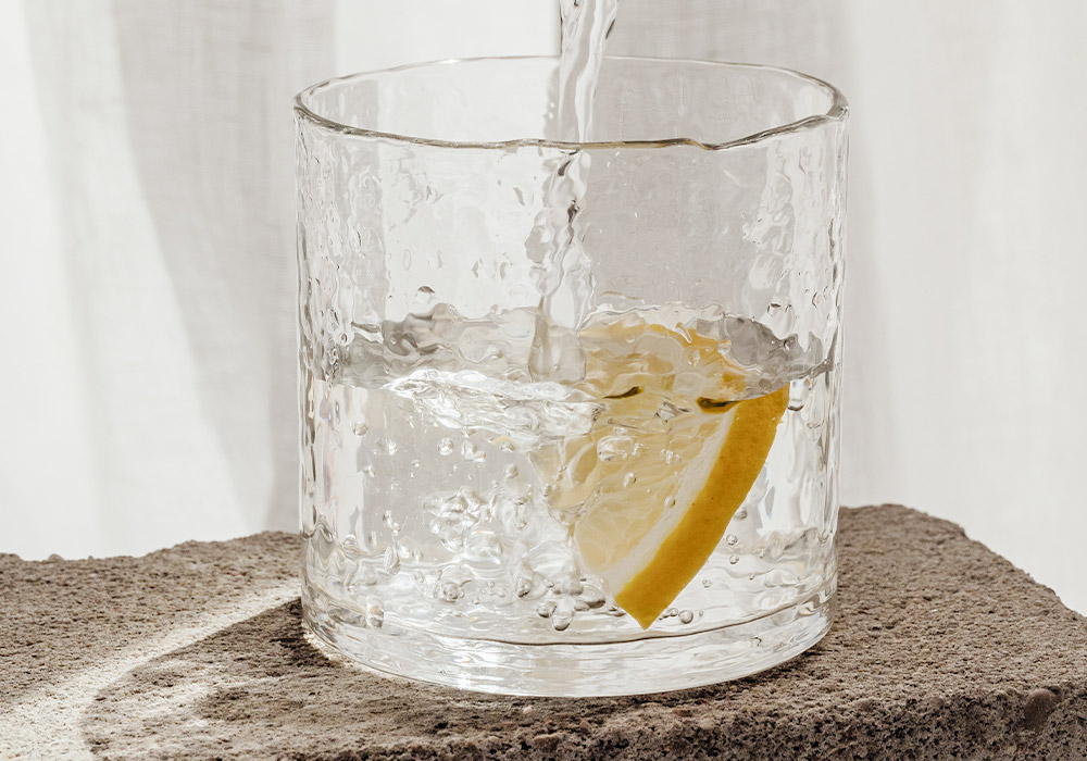Ein Glas Wasser mit einer Scheibe Zitrone.