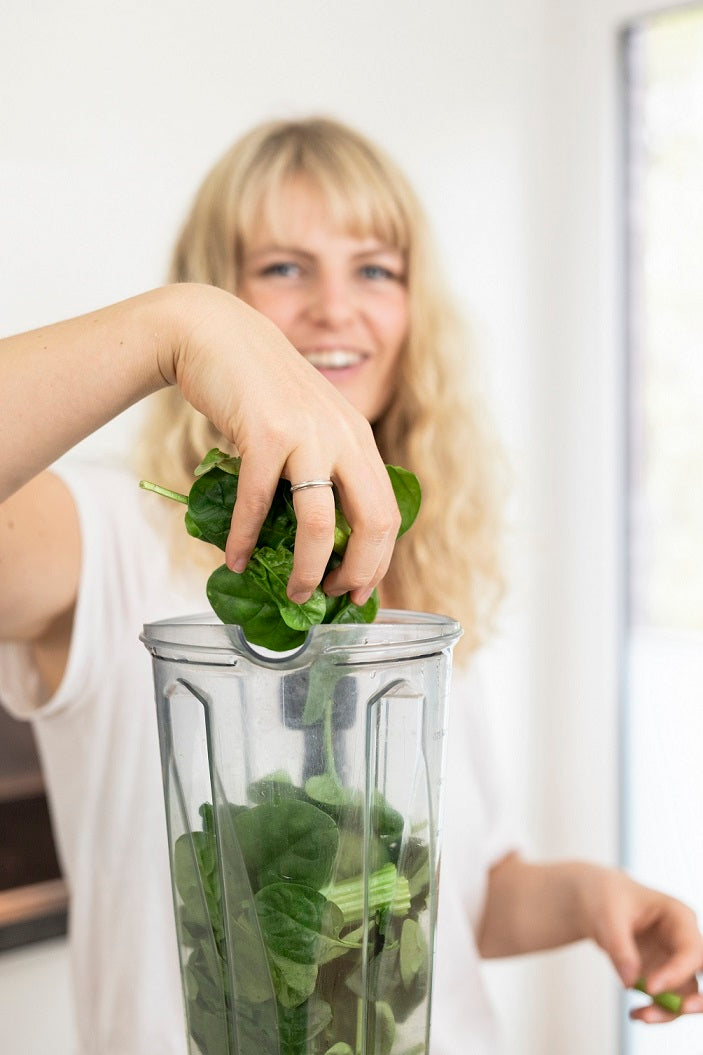 Julia macht Spinat in einen Smoothie