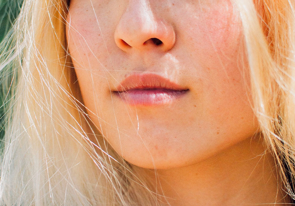 Bildausschnitt einer blonden Frau mit heller Haut.