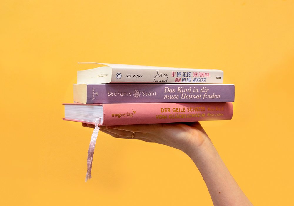 3 Bücher, die von einer Hand gehalten werden