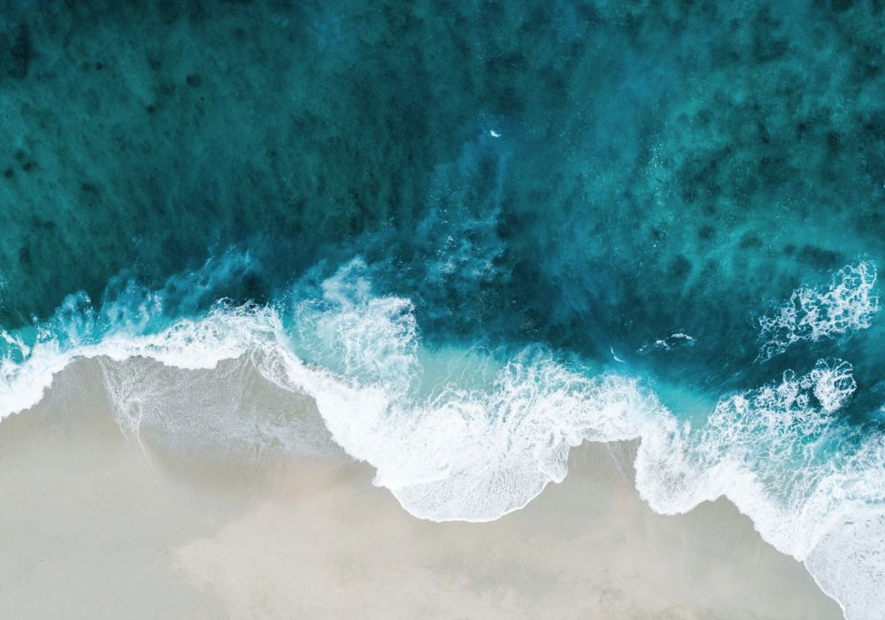 Aufnahme Meereswellen an einem Sandstrand von oben (Omega 3 Artikel)