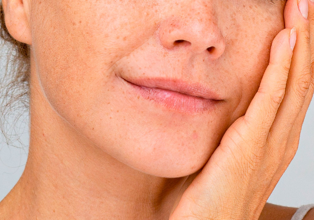 Nahaufnahme Gesicht einer Frau mit Hand auf der Wange