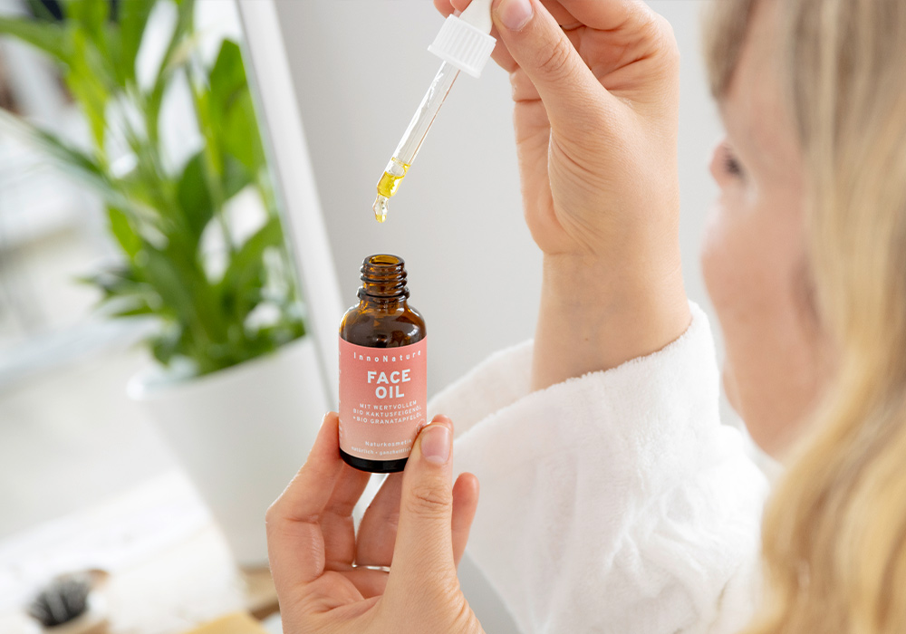 Julia entnimmt Öl aus dem InnoNature Face Oil Fläschchen