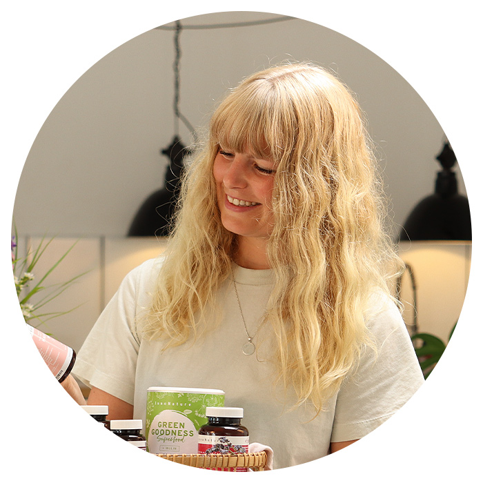 Julia lächelt, während sie InnoNature Produkte betrachtet