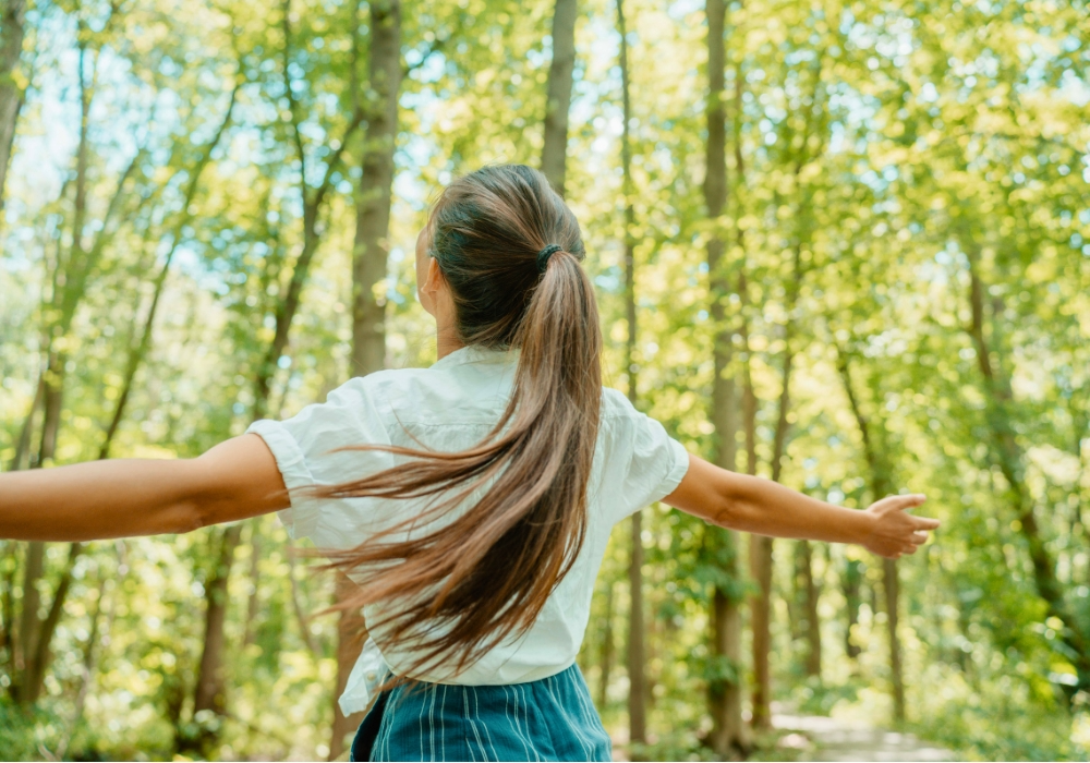 Ausgeglichene Person steht entspannt in einem Wald