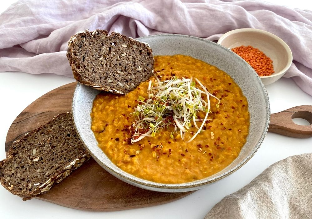 Linsen-Kokos-Curry-Suppe mit Sprossen Topping. 