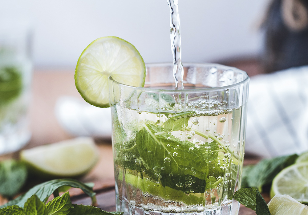 Glas mit Limette und Minzblättern. 