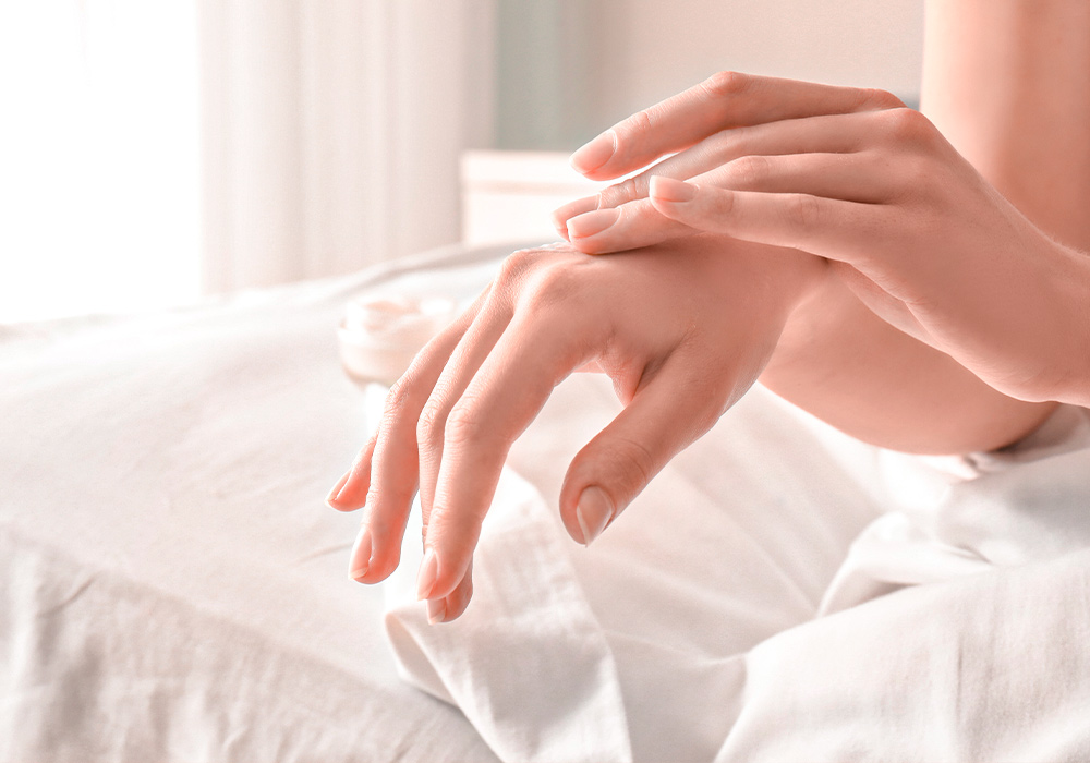 Eine Frau streicht sich mit der einen Hand über die andere