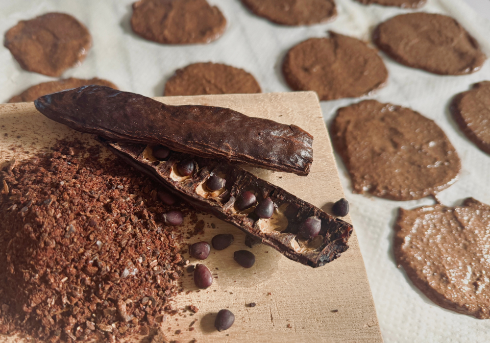 Karob Schoten und gemahlenes Pulver und Cookies