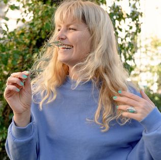 Julia riecht an einer Blume.
