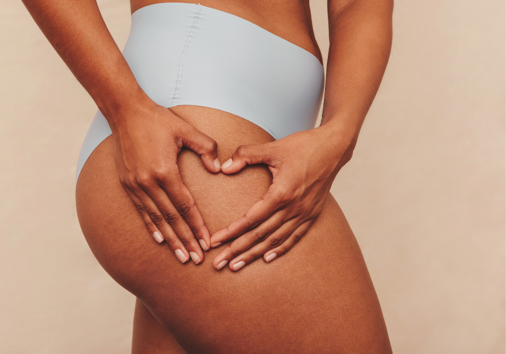 Frauenbeine und Hände formen Herz darauf